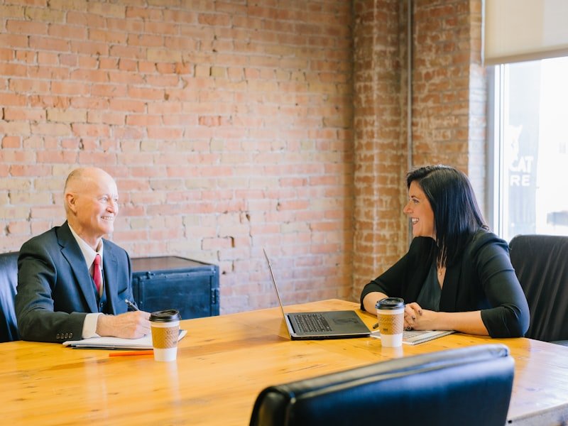Two professionals reviewing documents across a desk — year-end preparation for your accountant